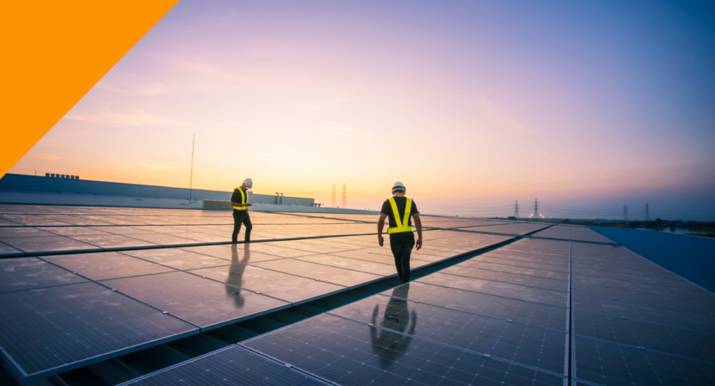 Two engineers inspecting a large solar panel installation at sunset, highlighting renewable energy and sustainable technology in action.