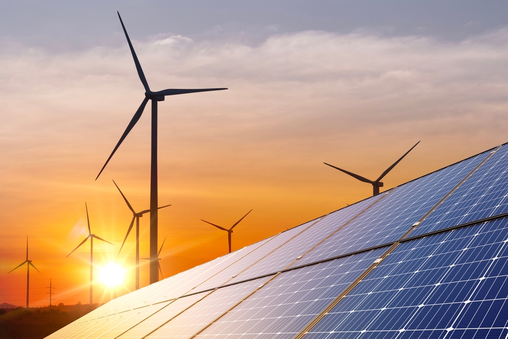 Renewable energy synergy: solar panels and wind turbines against a vibrant sunset.