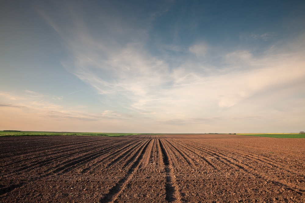 A wide-angle view of a plowed field used for land leasing for solar farms